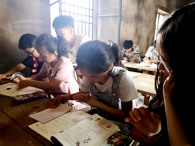 0-5”启明“团队成员正在帮助辅导暑假作业.jpg